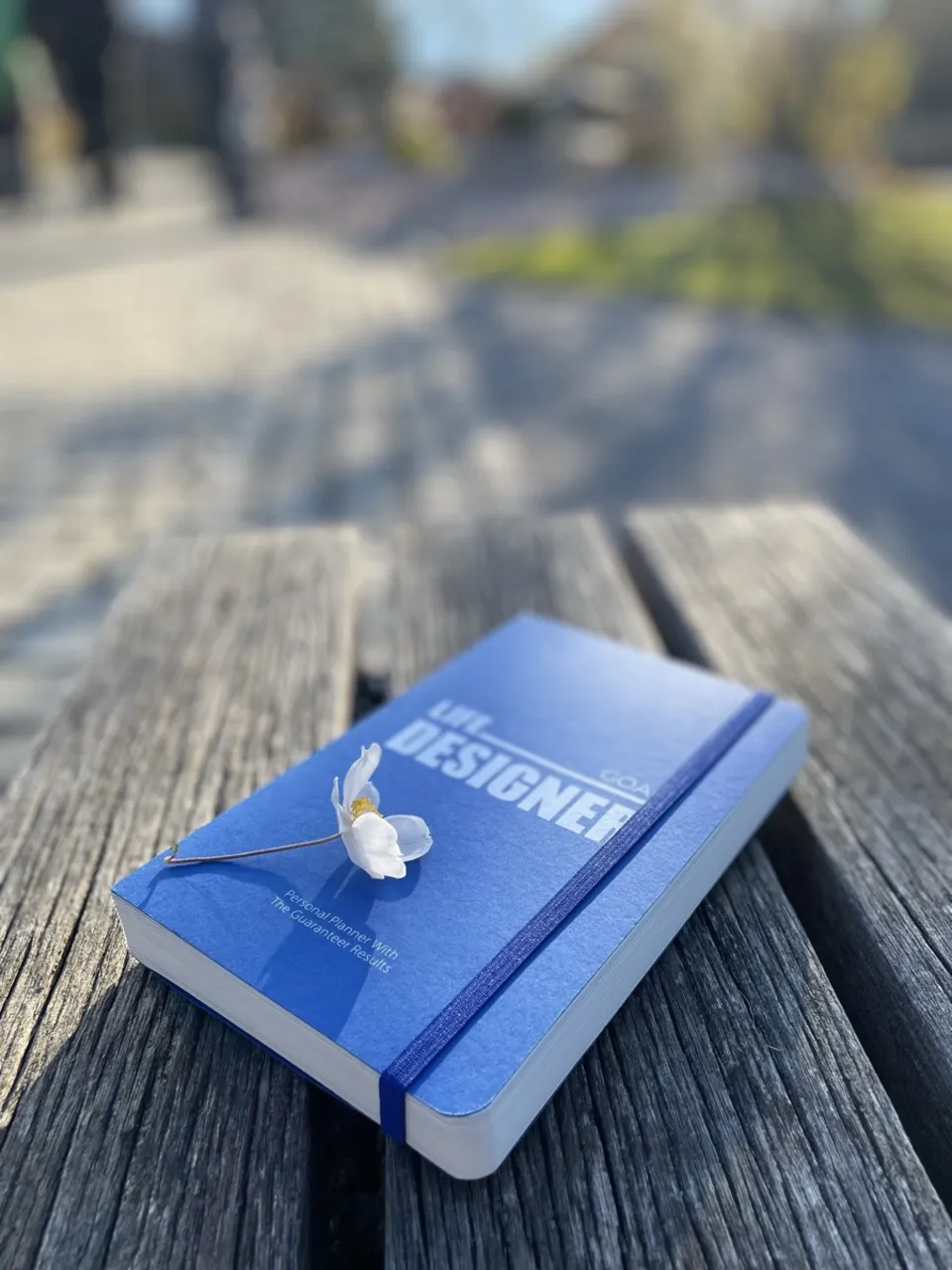 Life Designer GOAL planner with a flower on a bench